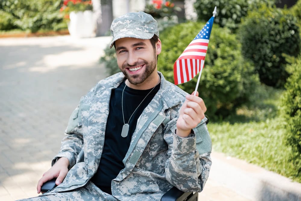 A soldier on a wheelchair holding a USA flag