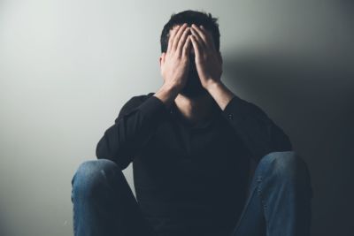 A depressed man sitting in a corner